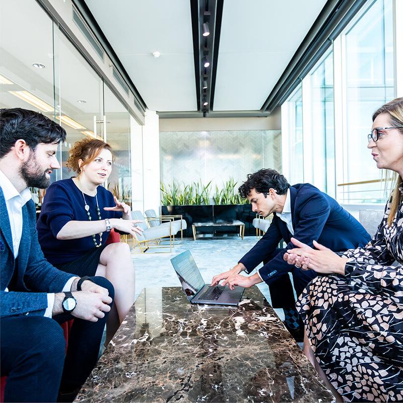 Four people having a meeting around a table in an office